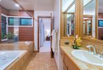 The attached master bathroom comes complete with twin vanities and sinks, as well as an oversized soaking tub with a shower